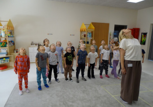 31 Dzieci z panią podczas zabawy muzyczno - ruchowej utrwalającej kierunki w przestrzeni i stronności własnego ciała