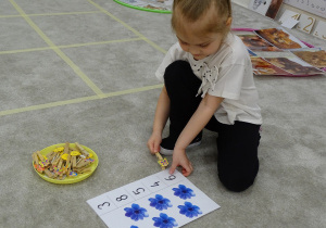 37 Dziewczynka przypina klamerkę do odpowiedniej cyfry