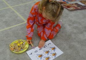 38 Dziewczynka przypina klamerkę do odpowiedniej cyfry