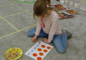 39 Dziewczynka przypina klamerkę do odpowiedniej cyfry