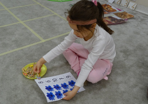 40 Dziewczynka przypina klamerkę do odpowiedniej cyfry