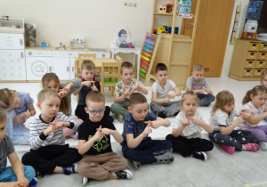 46 Dzieci pokazują za pomocą palców kolejny znak matematyczny