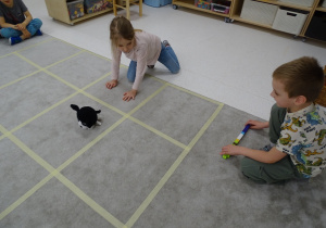 54 Dziewczynka ustawia pieska w kierunku, który pokazuje chłopiec za pomocą strzałki