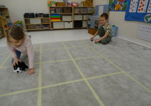 55 Dziewczynka ustawia pieska w kierunku, który pokazuje chłopiec za pomocą strzałki