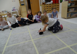 60 Dziewczynka ustawia pieska w kierunku, który pokazuje druga dziewczynka za pomocą strzałk