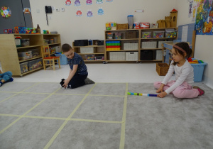 62 Chłopiec ustawia pieska w kierunku, który pokazuje dziewczynka za pomocą strzałk