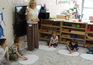 75 Dzieci układają na dywaniku koraliki zgodnie z pokazaną cyfrą