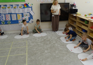 76 Dzieci dokładają na dywanik koraliki zgodnie z pokazaną cyfrą