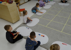 78 Dzieci wykonują polecenia matematyczne na dywaniku