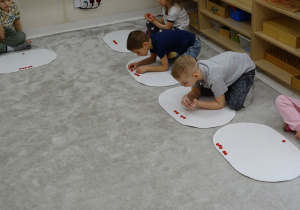 79 Dzieci wykonują polecenia matematyczne na dywaniku