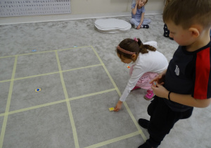 85 Dziewczynka układa figurę gometryczną na odpowiednim polu