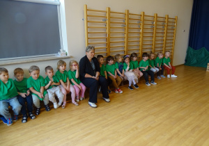 dzieci siedzą na sali gimnastycznej