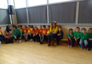 dzieci siedzą na sali gimnastycznej