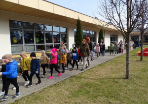 dzieci z paniami idą w korowodzie