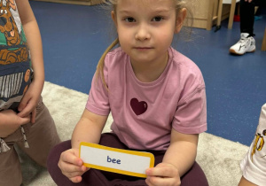 Dziewczynka trzyma kartę z nazwą