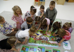 dzieci szukają na plakacie oznak wiosny