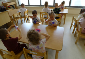 dzieci kolorują butelkę