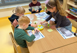 dzieci przyklejają obrazki do garnka