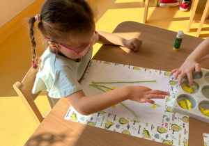 dziewczynka przykleja bibułę