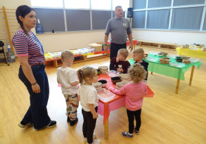 dzieci dekorują pojemnik ziemią