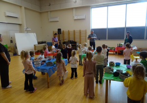 dzieci dekorują pojemnik ziemią