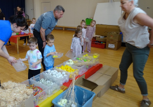 dzieci dekorują pojemnik ziemią