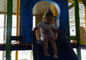 dziewczynka zjeżdża na zjeżdżalni