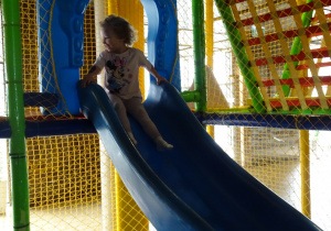 dziewczynka zjeżdża na zjeżdżalni