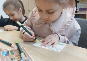 Dziewczynka ozdabia pocztówkę