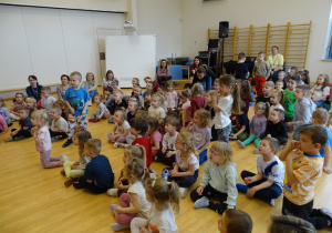 dzieci siedzą na sali gimnastycznej