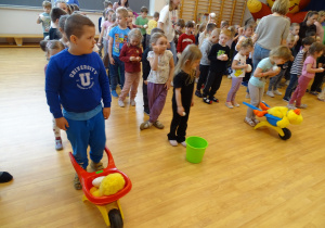 dzieci trzymają taczki