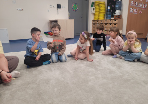 dzieci witają się podając sobie przy pomocy spinacza do bielizny skarpetkę z pianki