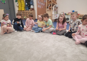 Dzieci podają sobie skarpetkę