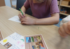 Dziewczynka ozdabia pocztówkę