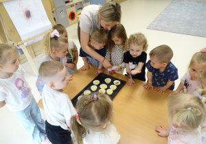 dziewczynka posypuje babeczki czekoladą