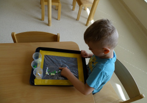 chłopiec przepycha pomponiki