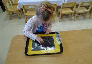 dziewczynka przepycha pomponiki