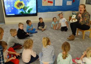 Logopedka prezentuje kolejne ćwiczenie a dzieci naśladują