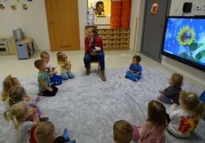 Logopedka wskazuje gestem, gdzie dzieci układają język