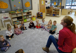 Dzieci wykonują przed logopedą ćwiczenia języka