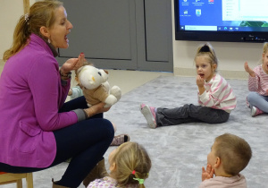 Dzieci z logopedą próbują zrobić miseczkę z języka