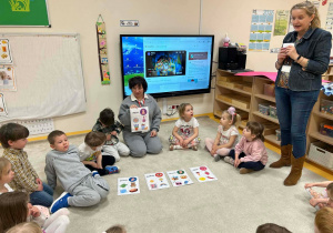 Logopeda opowiada, a dzieci siedzą w kole i słuchają