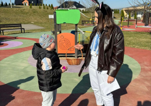 Chłopiec wkłada jajko do koszyczka