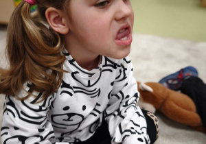 Dziewczynka dotyka zębów górnych