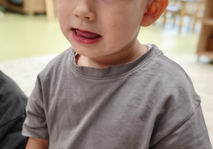 Chłopiec liczy językiem zęby górne