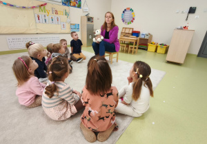 Logopeda ćwiczy z dziećmi siedzącymi w kole