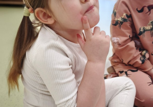 Dziewczynka dotyka policzka, by tam poczuć język