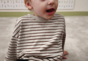 Chłopiec prezentuje ćwiczenie języka zwane zegar bim -bom