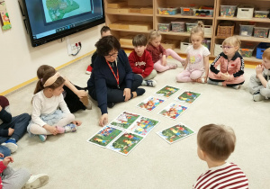 Dzieci wspólnie z nauczycielm opowiadaja układaja ilustracje z bajki