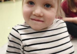 Dziewczynka chowa wargę dolną za zębami górnymi